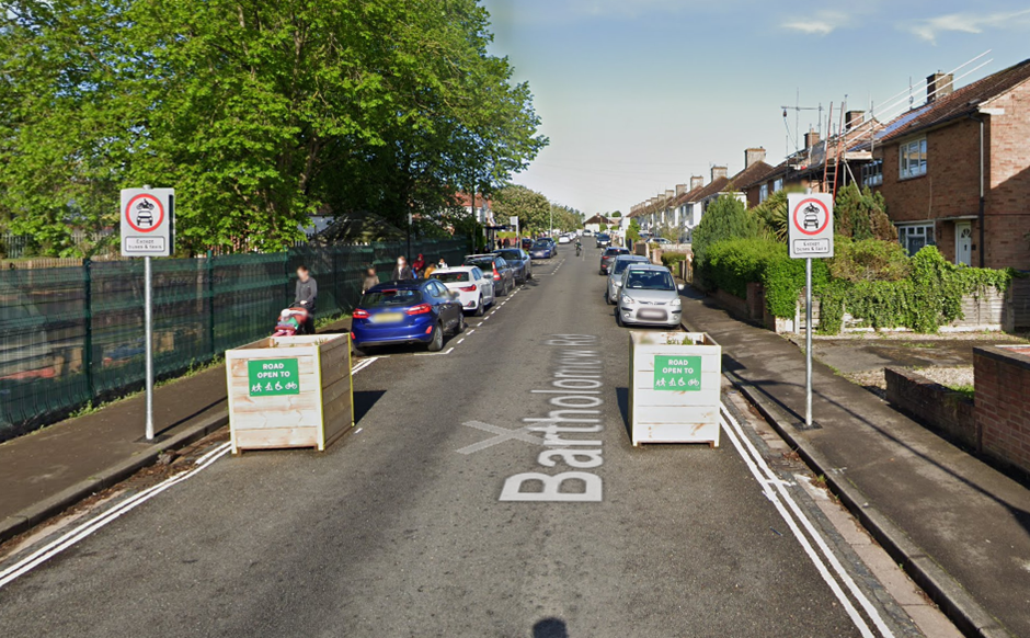 Google Streetview showing a traffic filter comprising wooden planters and traffic signs on Bartholomew Road, a residential street in Oxford