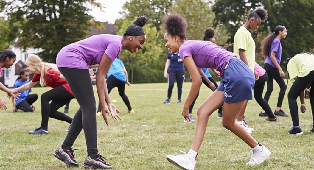 A group of teenage girls on a playing field doing sport