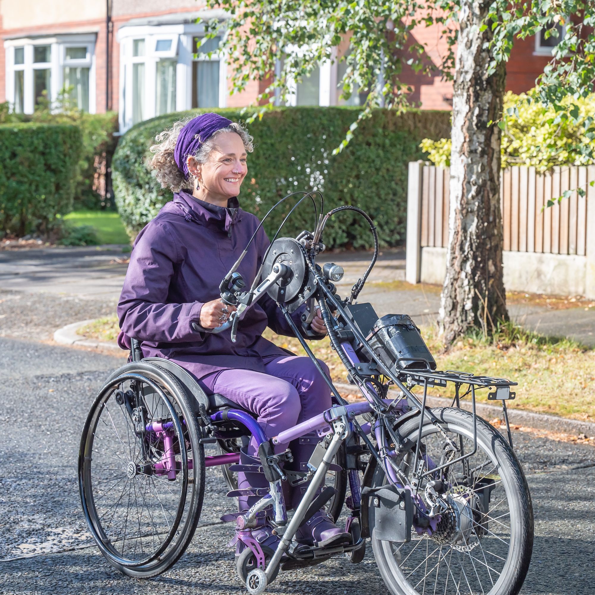 A woman using a handcycle on a quiet road