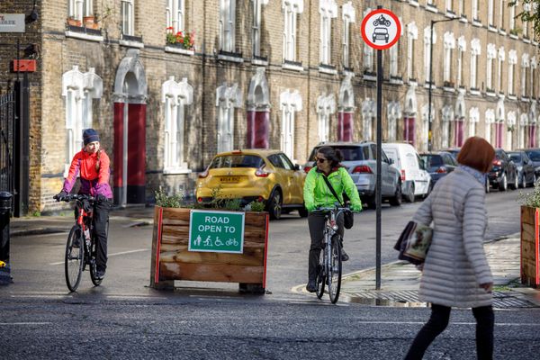 Two women cycling either side of a planter within a low traffic neighbourhood