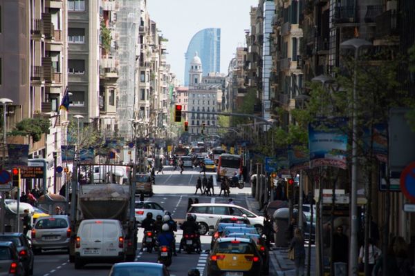 Busy Barcelona road scene showing motor vehicles mixing with pedestrians 