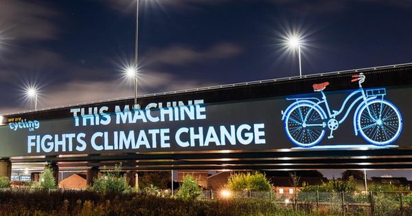A billboard showing a picture of a bicycle beside the caption "THIS MACHINE FIGHTS CLIMATE CHANGE"